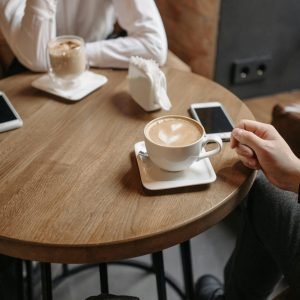 two people sitting at a table having coffee